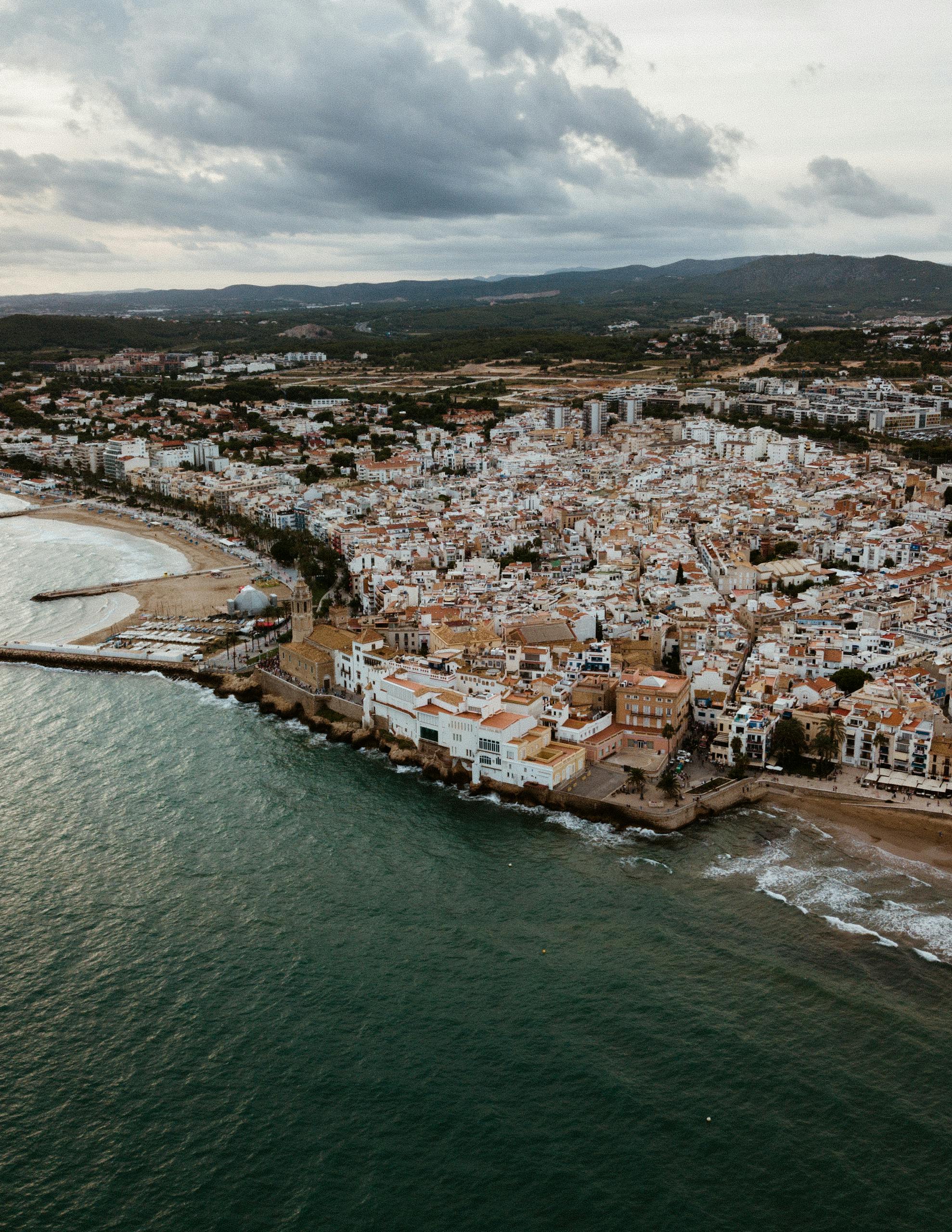 A stunning aerial shot capturing the coastal cityscape of Sitges, Spain with its vibrant waterfront.